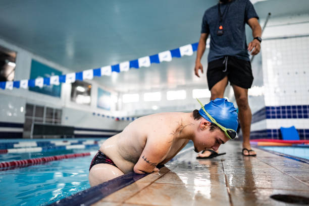 istock Competitive para athlete swimmer with double arm and leg amputations leaving pool 2165003629