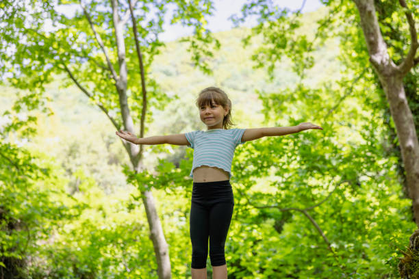 Little girl enjoying nature in green forest