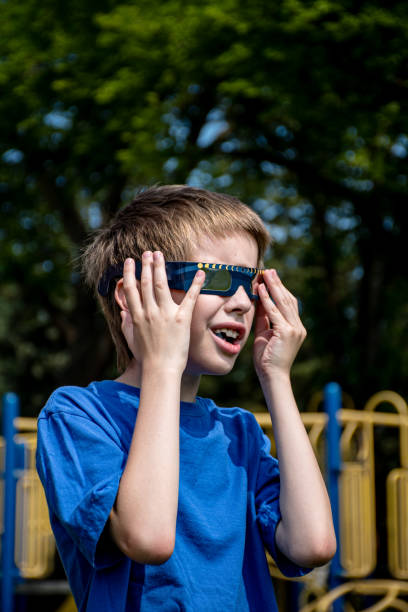 istock A 9-year-old mixed-race Canadian Caucasian boy safely viewing a solar eclipse using protective glasses at his school playground. 2165007350