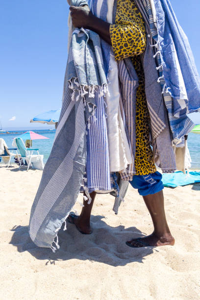 istock Beach Vendor Draped in Colorful Towels on Sandy Shore 2165008510