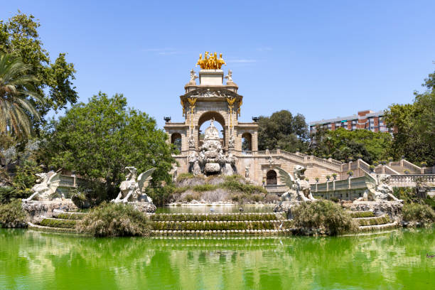 The ornate Cascada Monumental in Barcelona features elaborate sculptures and a golden chariot statue, viewed from the grand staircase below, Ciutadella Park