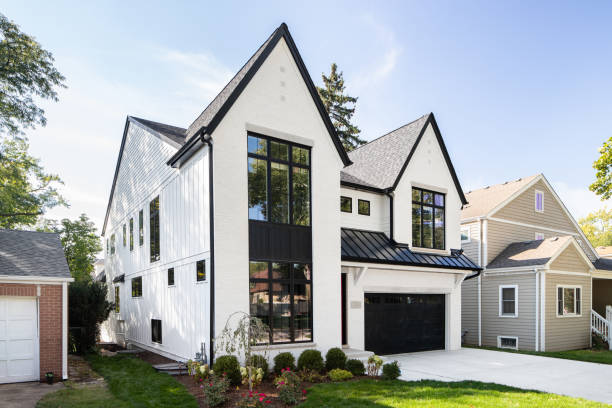Naperville, IL, USA September 29, 2022: A luxury home with white brick and board and batten siding, black framed windows, and black garage door.