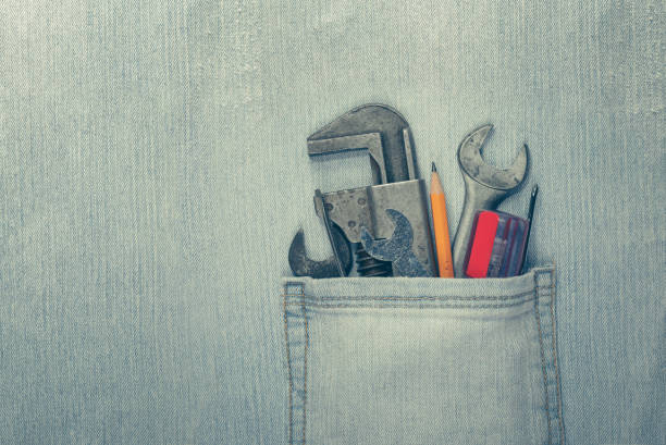 Worn and weathered blue jeans with work tools in the pocket. Home improvement or diy project, Labor Day, or Father's Day concept.