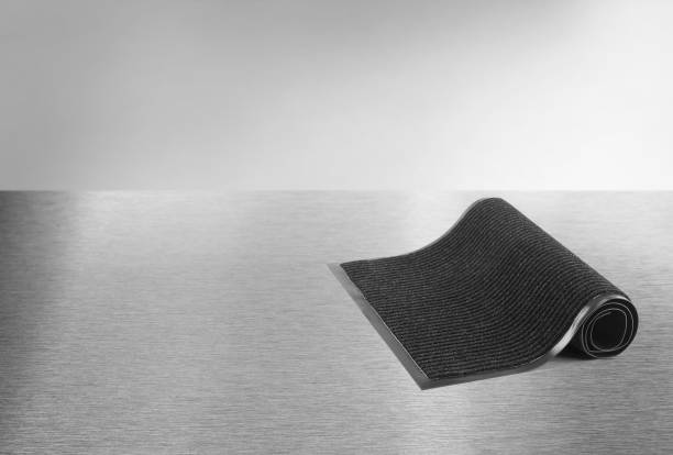 Rolled black protective door mat on a metal floor