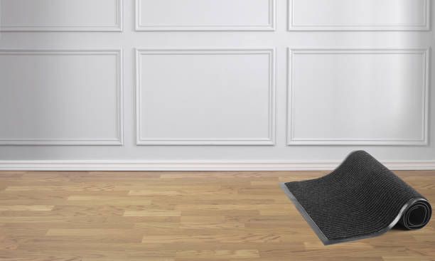Rolled black protective door mat in a room
