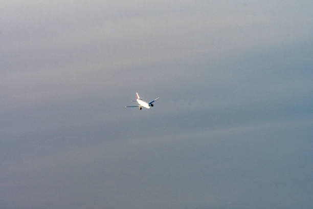 Sterling, Virginia, USA - December 11, 2023: Lufthansa Airlines Flight #LH418, a Boeing 747-830 passenger airplane, is silhouetted by the setting sun in late afternoon against a clear blue sky as it nears the end of its flight from Frankfurt, Germany, to Washington Dulles International Airport.