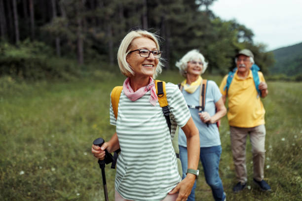 mature woman enjoying her day in forest with friends - åldrande bildbanksfoton och bilder