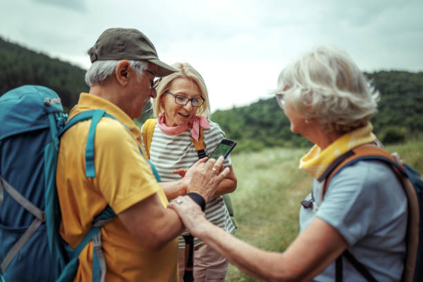 istock Group of senior hikers using smart phone while hiking together in forest 2165018239