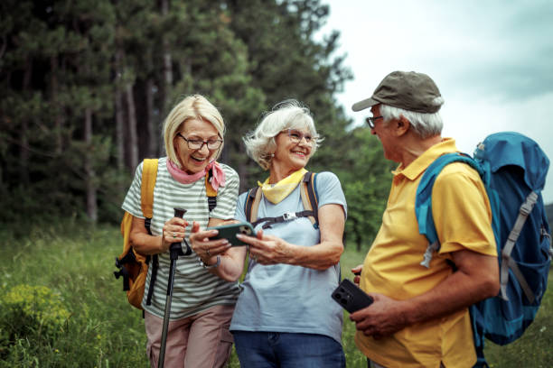 istock Group of senior hikers using smart phone while hiking together in forest 2165018243