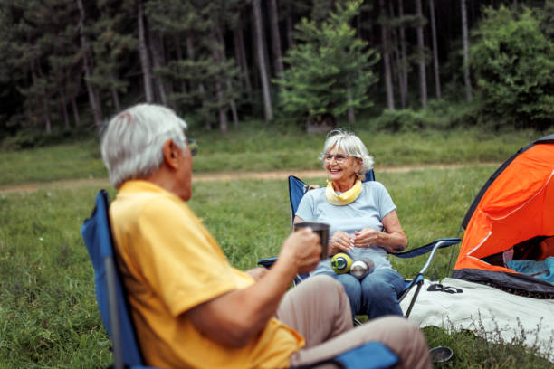 istock Senior couple enjoying hot coffee while camping together in forest 2165018310