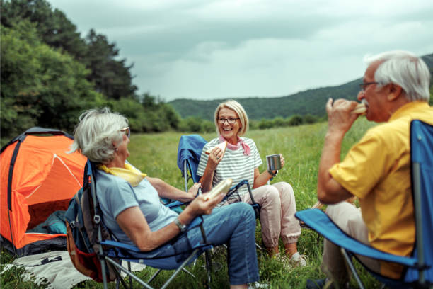 istock Senior couple enjoying camping with their daughter at forest 2165018335