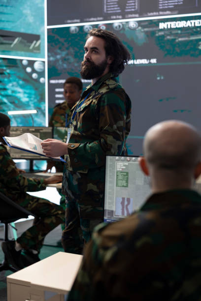 istock Army IT professional supervising data collecting activity from a big screen 2165022523