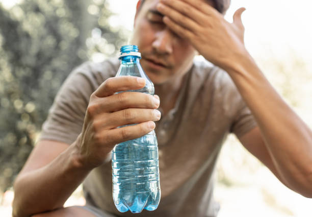 Man drinking water cooling off in extreme summer heat wave.