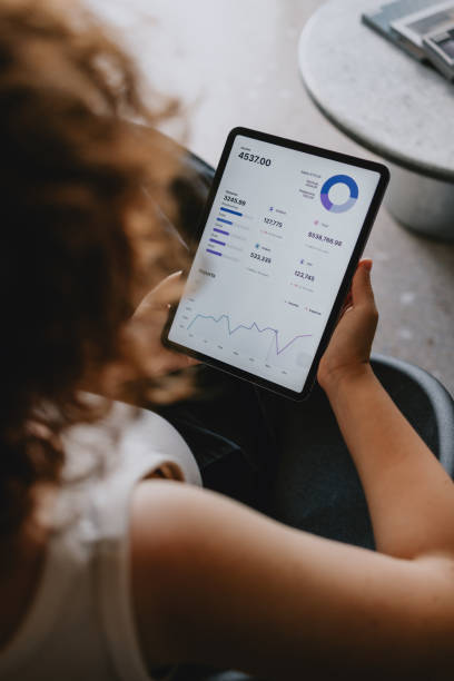 Businesswoman Analyzing Financial Data On Digital Tablet