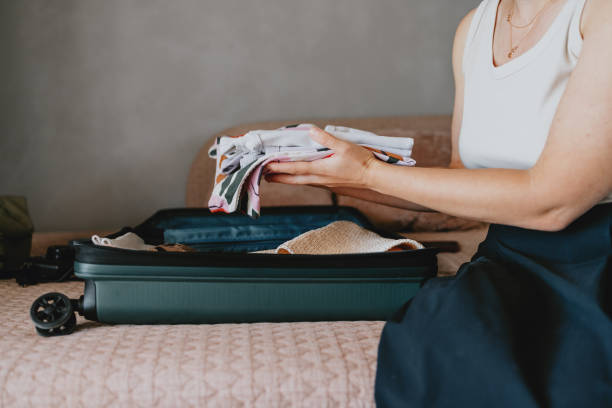 istock Woman Packing Suitcase for a Trip at Home 2165024810