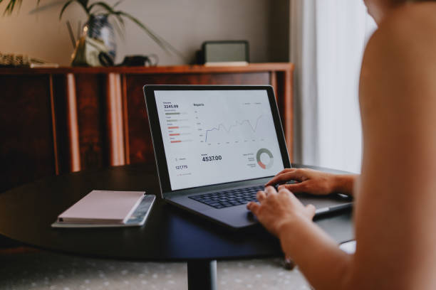 istock Businesswoman Analyzing Data and Reports on Laptop at Office Desk 2165024835