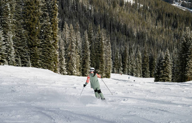 istock Woman in Green Carving Down Steep Ski Run 2165025113