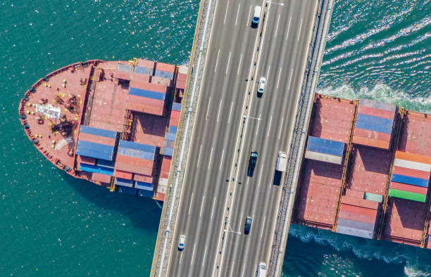 istock Aerial view of a cargo ship passing under bridge. Cargo Ship Beneath Bridge. 2165025467