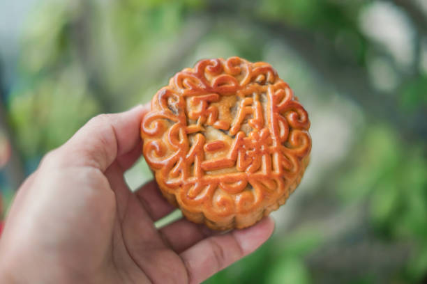 Close-up flatlay shot of Mooncake traditional Chinese pastry for Mid Autumn day festival, on top of a white play, with a red background
