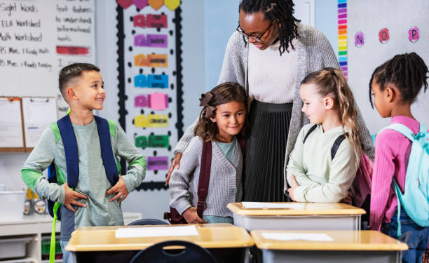 istock Elementary school teacher in classroom with four children 2165040669