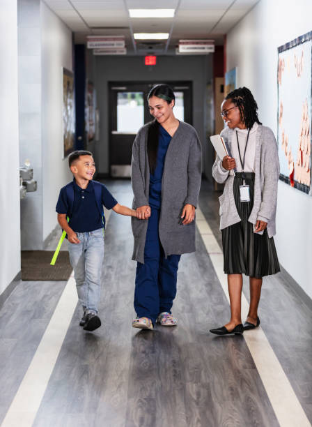 istock Hispanic mother in scrubs brings son to elementary school 2165040789