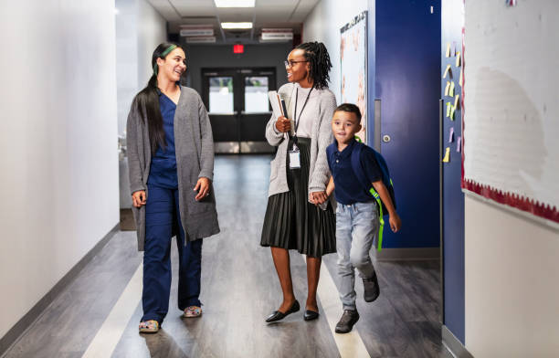 istock Hispanic mother in scrubs brings son to elementary school 2165040804