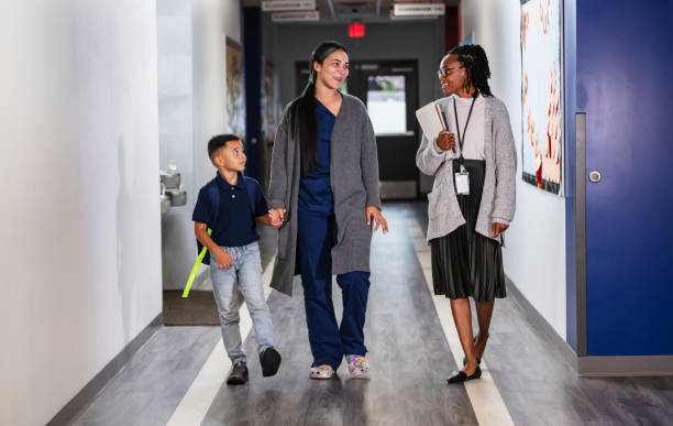 istock Hispanic mother in scrubs brings son to elementary school 2165040807