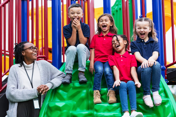 istock Teacher with excited children shouting on playground 2165040833