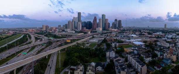 istock Urban sprawl under the twilight sky. Skyline in Houston, TX. Expansive highway system connects neighborhoods to towering downtown. Extra-large stitched panorama. 2165040997