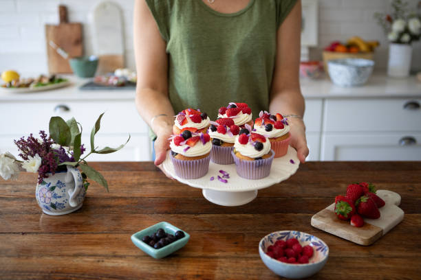 istock Woman's hands showing blueberry muffins and whipped cream 2165041677