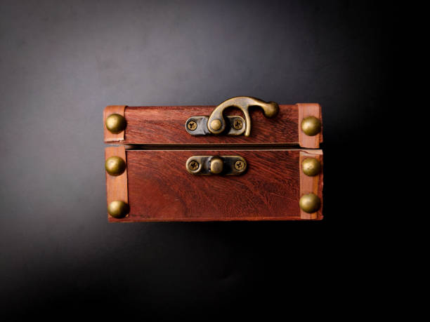 istock A locked mysterious wooden chest is on a black background. 2165053892