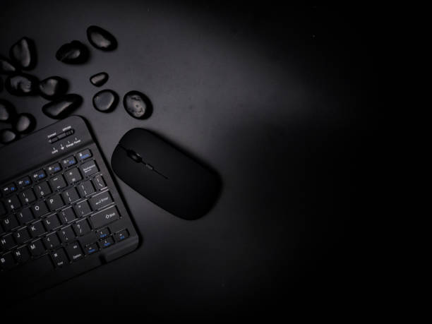 istock A black wireless keyboard and mouse with black stone on a black background. 2165053903
