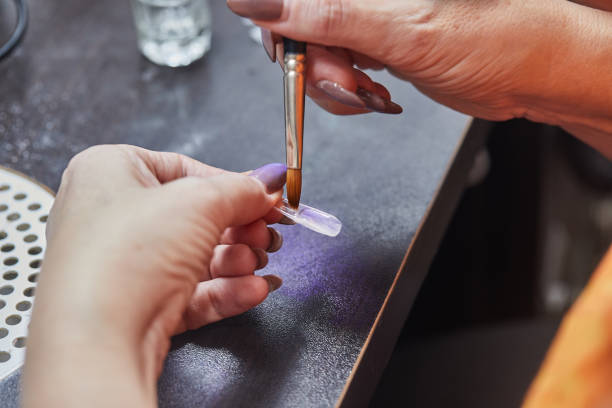 istock Nail Technician Applying Gel to Nail 2165054627