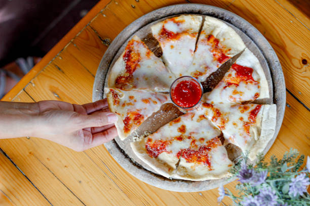 Soft light and Blurred image,Homemade pizza thin crust  pizza topping with seafood and cheese to the full range served on a round wooden tray to customers.copy space to insert text.