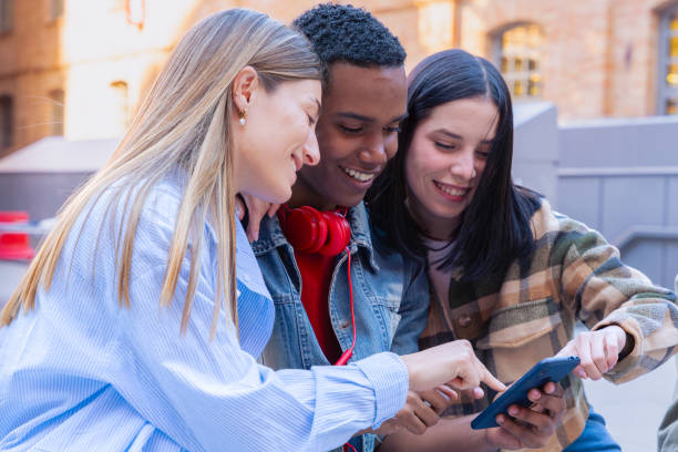istock Three students having fun with mobile phones creating content on social media. 2165056339