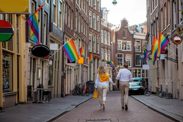 A middle aged couple made up of a beautiful woman and handsome man enjoying a morning walk whilst sightseeing in Amsterdam