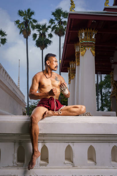Man athletic bodybuilder poses with nude torso abs in full-length background, boxing and martial arts. Advertising, sports, active lifestyle, color light, competition, challenge concept. . High quality photo