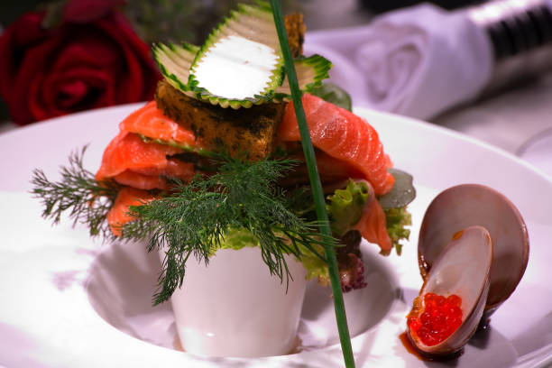 A table set with a variety of fish such as salmon and tuna, grilled meats including beef steaks and lamb chops, and white meats like roast chicken and duck à l'orange.