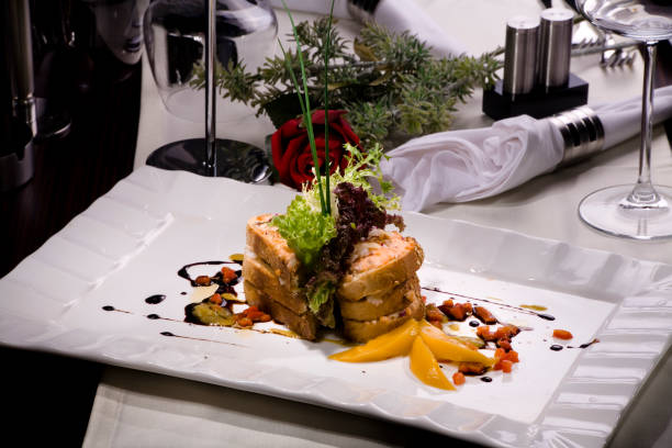 A table set with a variety of fish such as salmon and tuna, grilled meats including beef steaks and lamb chops, and white meats like roast chicken and duck à l'orange.