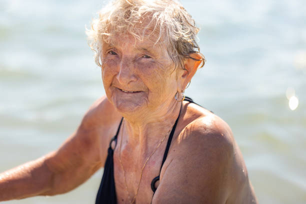 istock Assisting Senior at the Beach 2165060163