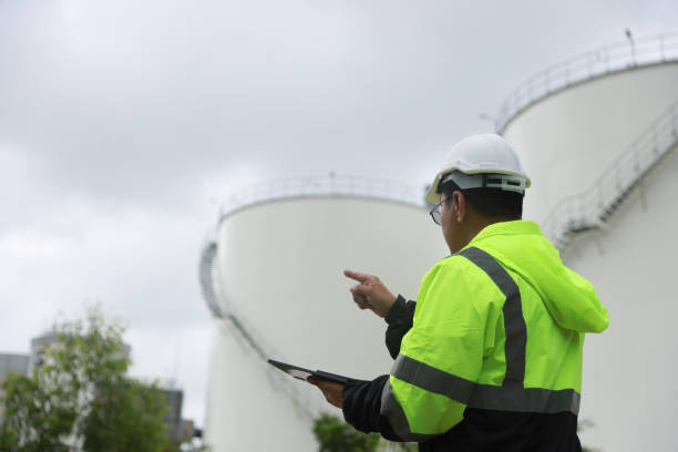 istock Senior project engineer wears hard hat working on a digital tablet at the site power plant, project engineer checks liquid inventory storage of petroleum plant, Engineering, and Industrial concept 2165061828
