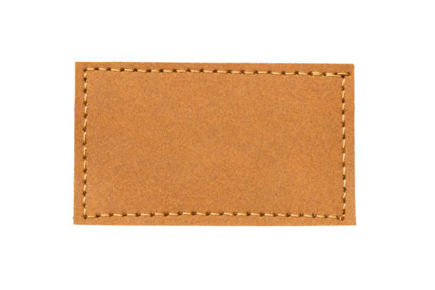 istock Brown leather belt strap closeup isolated on white. Brown stitched leather seam frame label tag isolated on white. Sewing background. 2165062130