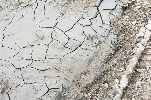istock Dry ground cracked background. Soil after drought pattern. Cracks on sandy earth texture. 2165062294