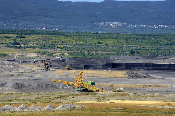 Aerial view of a lignite surface mine with a giant bucket-crawler excavator and conveyor belt.