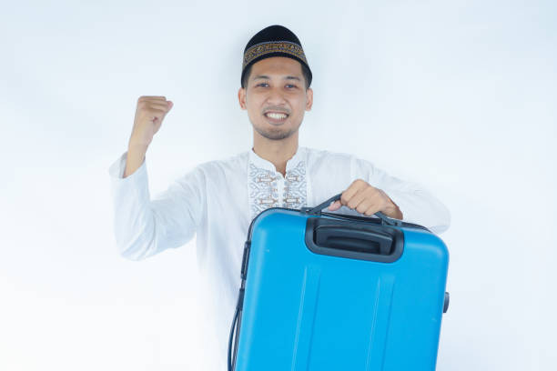 istock Moslem Asian man carrying suitcase with excited expression 2165084169