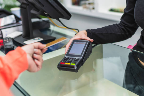 istock A woman is paying for something at a store using a card reader 2165085792