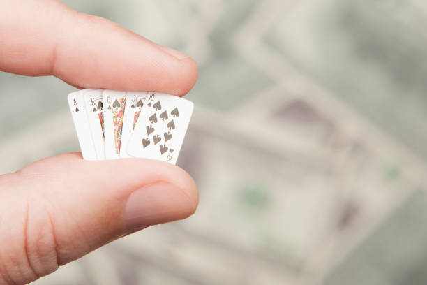 istock image of playing card hand money dollar banknote background 2165090242