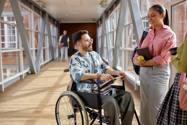 istock Young Male Student with Disability Chatting with Friends 2165091330