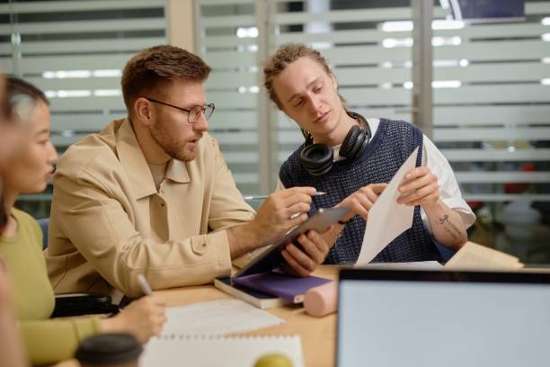 istock University Student Asking Professor Question Pointing at Paper 2165092034