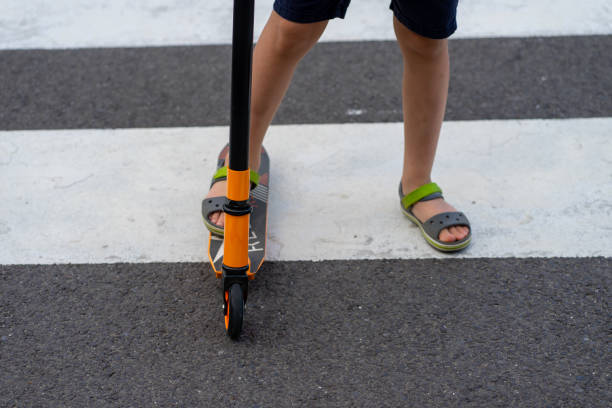 istock A child on a scooter walks along a pedestrian crossing 2165102930